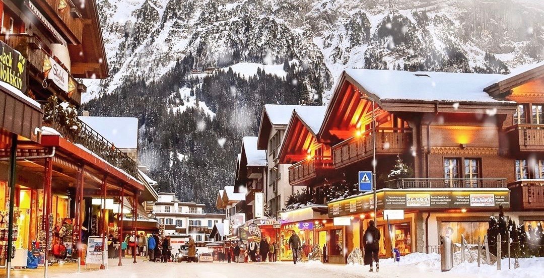 Grindelwald’da karlı Alp evleri ve dağ silüeti